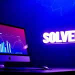 Computer monitor displaying sales analytics graph with the word "SOLVED" illuminated, representing AI-powered CRM solutions for enhancing sales processes.